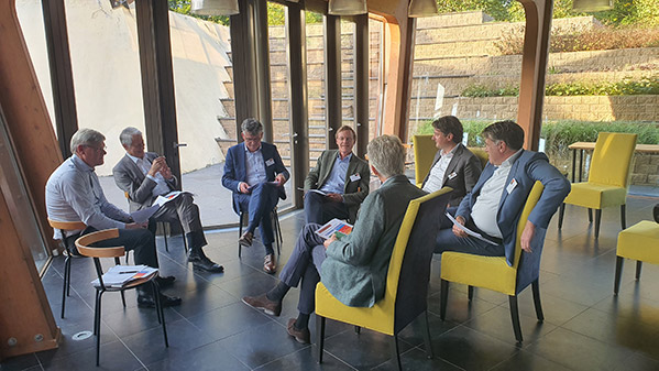 JBR Interim Executives Round Table WHOA sieben Männer in Anzügen reden miteinander